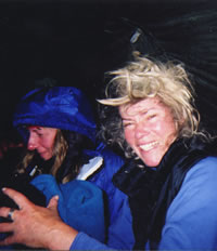 Gail Bosio and Jane Bewith enjoy a laugh under the shelter of Mary Powell's tarp shelter