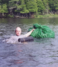 Michael Neiger swims a lake narrows with his pack, using his closed-cell foam pad as an improvised PFD